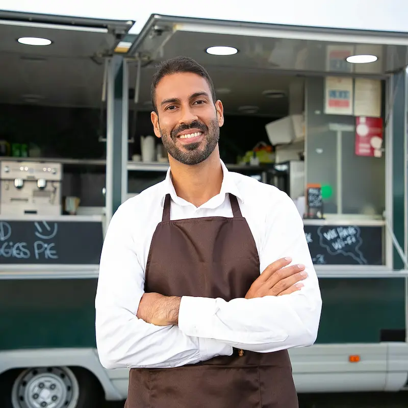 Food truck owner standing in front of a parked food truck