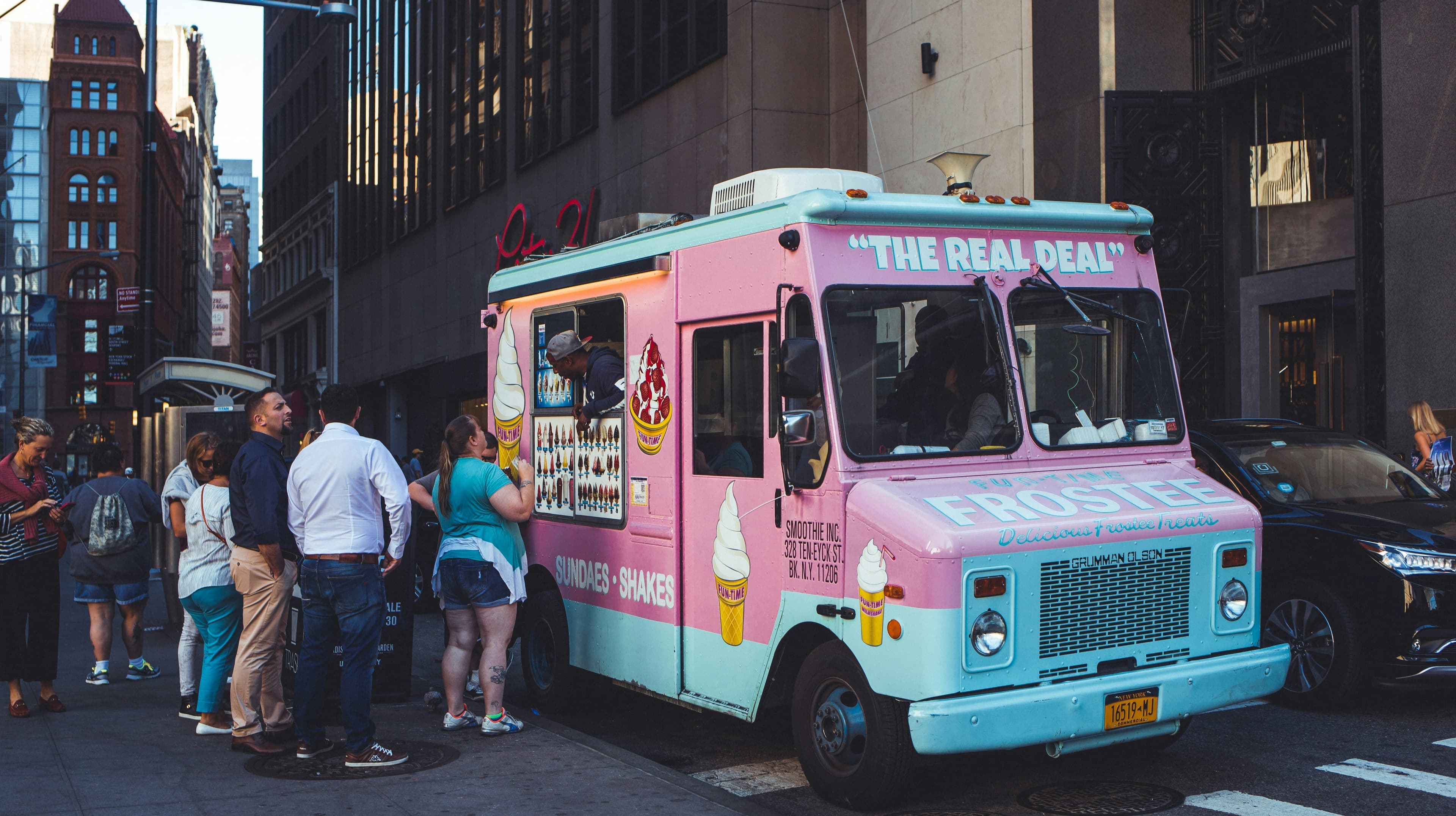 A food truck owner serving customers at a busy curbside