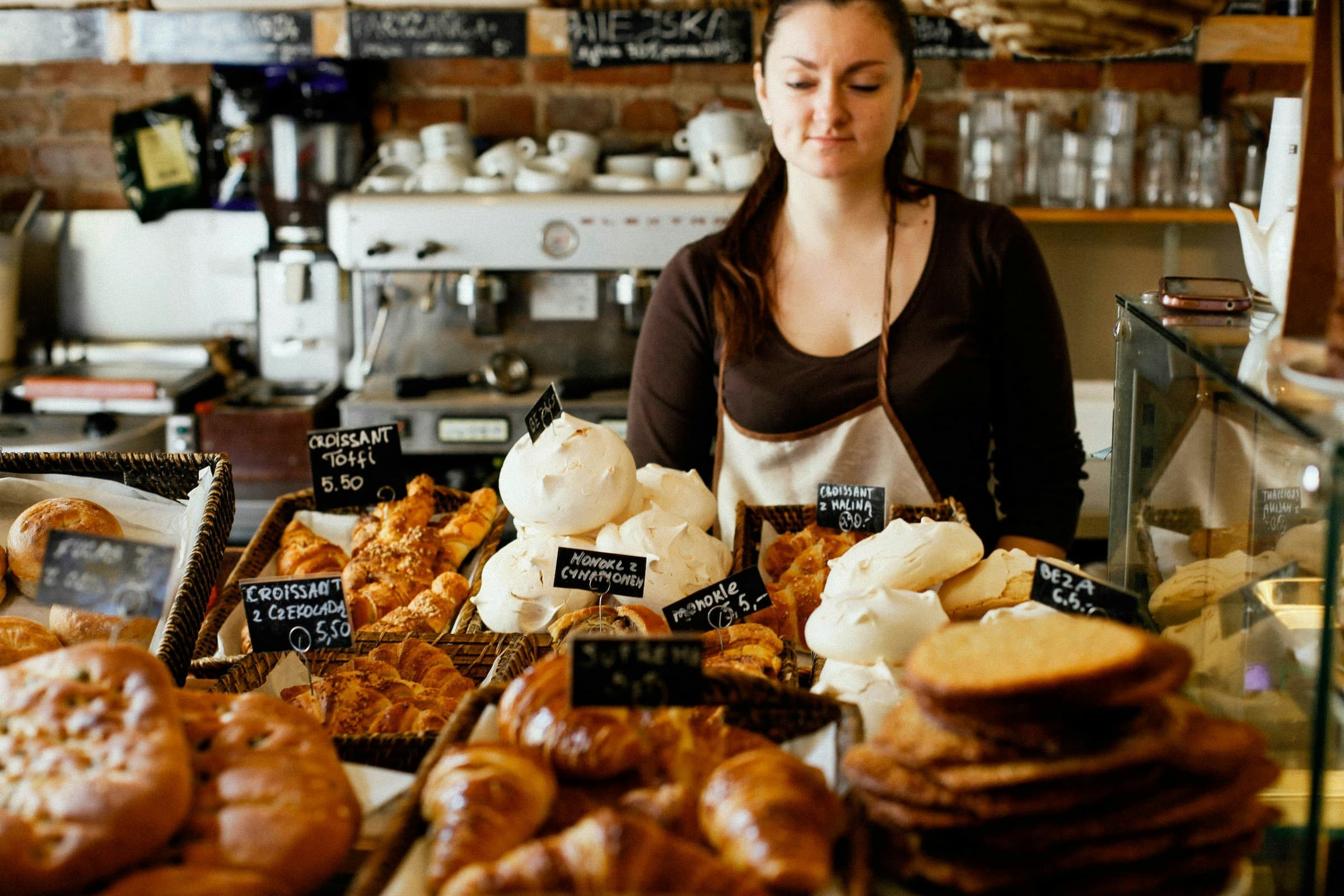Baker pulling a tray of laminated pastries from the oven before opening